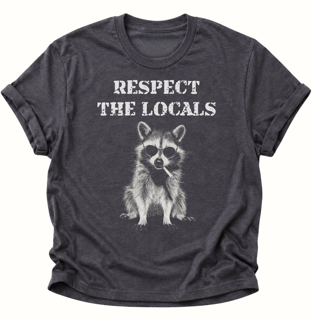 Dark heather Unisex T-Shirt mit lässigem Waschbär, Zigarette und weißem Schriftzug von Pine & River.
