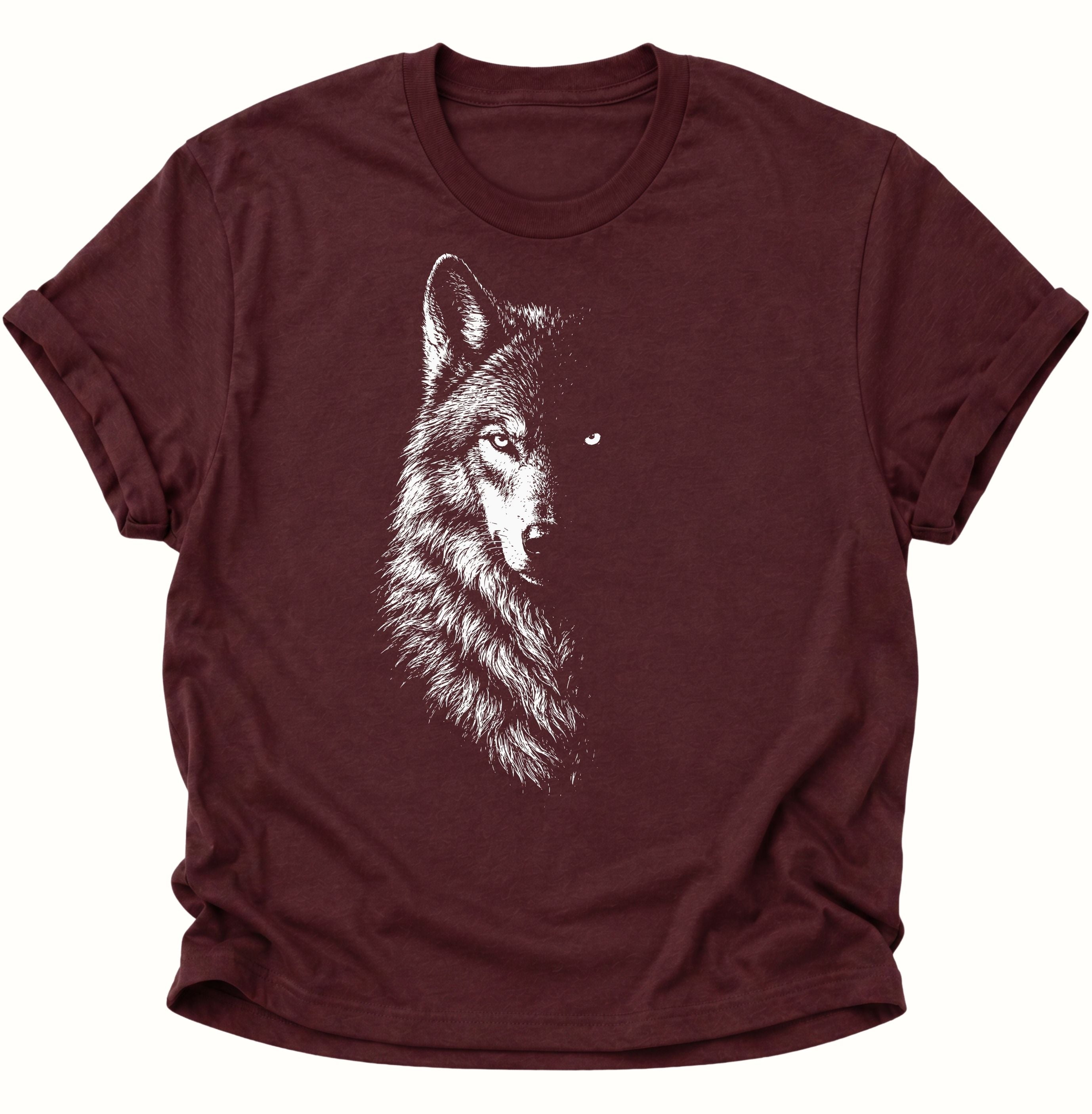 Maroon Unisex T-Shirt mit Wolfsporträt, markantem Blick und dunkler Gesichtshälfte von Pine & River.
