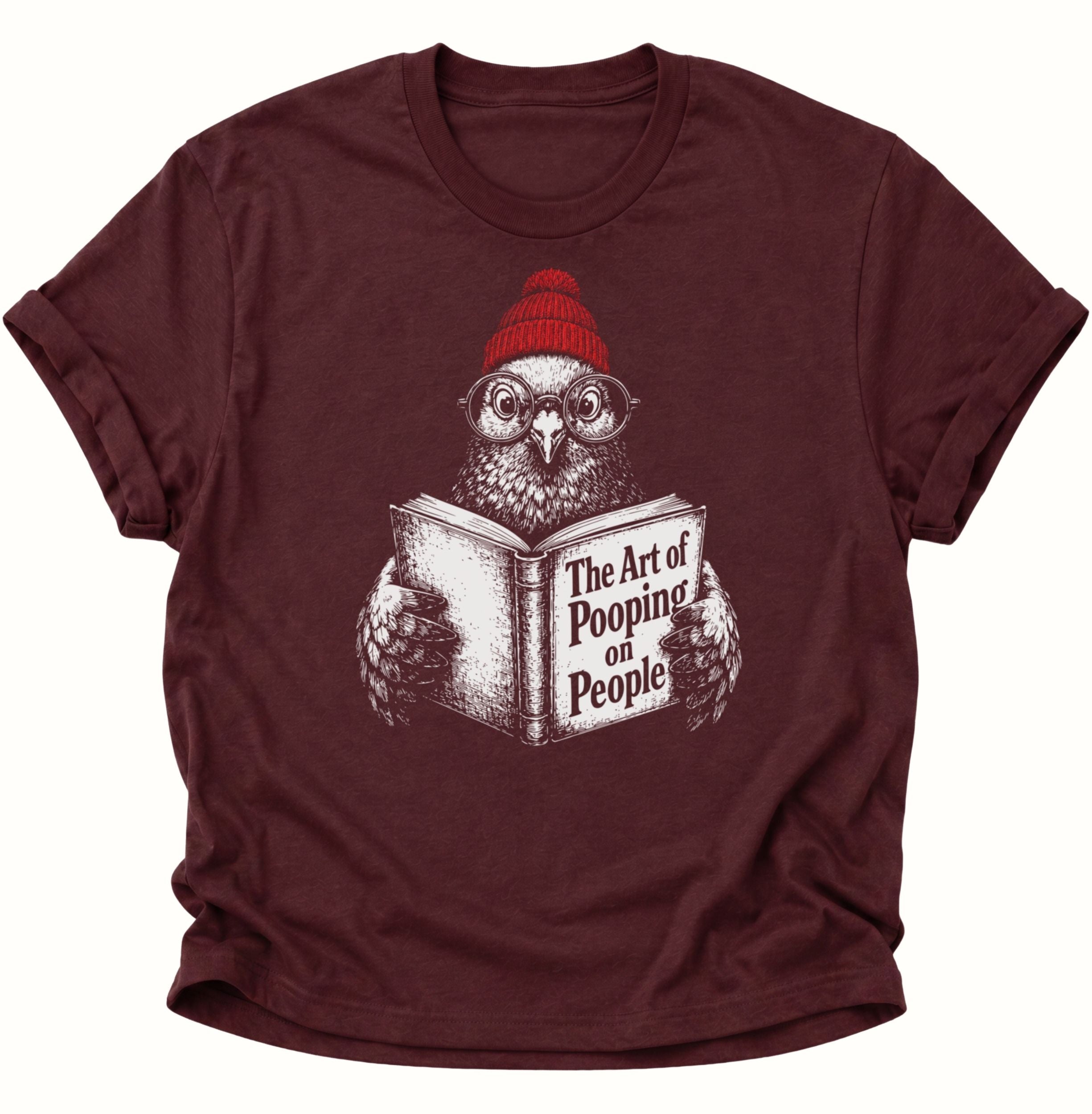 Maroon Unisex T-Shirt mit Vogel, roter Mütze, Rundbrille und „The Art of Pooping on People“ von Pine & River.
